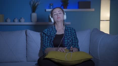 Depressed-woman-listening-to-music-at-home-at-night.
